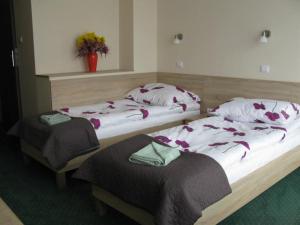 dwa łóżka w pokoju z kwiatami w obiekcie Willa Sole w Busku Zdroju