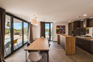 a kitchen and dining room with a long wooden table at Hotel Olea in Novalja