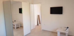 a room with a mirror and a tv on a wall at House Mergi in Pomer