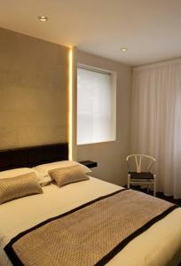 A bed or beds in a room at NOX Belsize Park