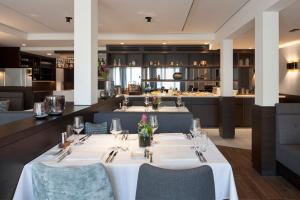 a dining room with two tables and a bar at Hotel Schwanen in Köngen