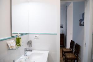 ein weißes Badezimmer mit einem Waschbecken und einem Spiegel in der Unterkunft Vesuvio Blu in Neapel