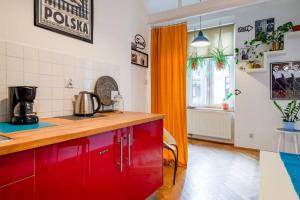 uma cozinha com armários vermelhos e uma cortina laranja em Blue Peace-apartment with FREE PARKING in center for 1-6 people em Cracóvia