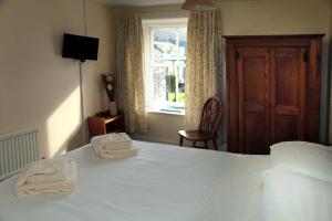 a bedroom with a bed with two towels on it at The Sun Inn in Dent