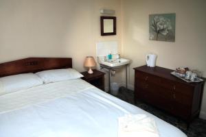 ein Schlafzimmer mit einem Bett und einem Waschbecken darin in der Unterkunft The Sun Inn in Dent