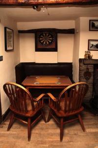 a wooden table and two chairs in a room at The Sun Inn in Dent