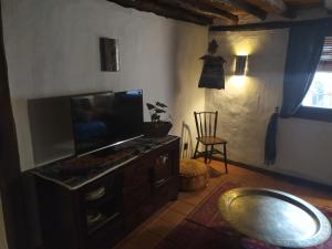 ein Wohnzimmer mit einem Flachbild-TV auf einer Kommode in der Unterkunft Apartamento Al-Vivaque in Miranda del Castañar