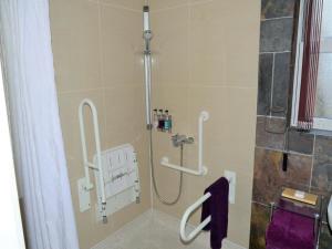 a shower stall in a bathroom with purple towels at Wildercombe House in Ilfracombe