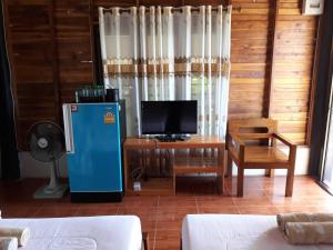 a living room with a blue refrigerator and a desk at บ้านสวนศรเพชร in Phetchabun