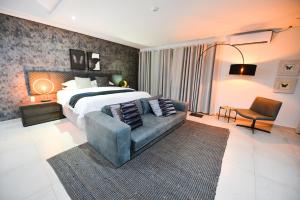 ein Schlafzimmer mit einem großen Bett und einem Sofa in der Unterkunft Serurubele Boutique Hotel in Bushbuckridge