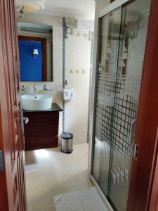 a bathroom with a sink and a glass shower at Hotel Nikko Towers in Dar es Salaam