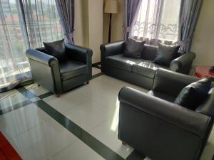 sala de estar con 2 sofás y 2 sillas en Hotel Nikko Towers, en Dar es Salaam