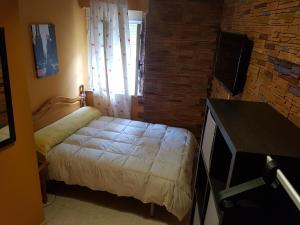 a small bedroom with a bed and a window at Casa Foz in Foz