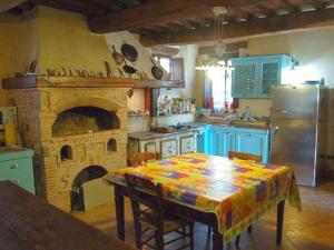 a kitchen with a table and a stone oven at Monastery Guest House in Lerchi