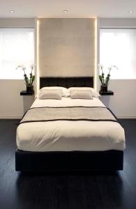 a large bed in a bedroom with two windows at NOX Belsize Park in London