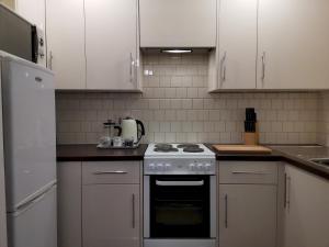 a kitchen with white cabinets and a stove top oven at Apartment Bournemouth centre close to beach in Bournemouth