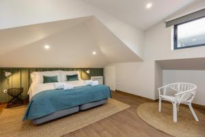 Un dormitorio con una cama grande y una silla. en Feel Porto Wine Essence Apartments, en Vila Nova de Gaia 27 fotos más