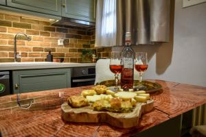 a table with two glasses of wine and a plate of food at La Casa Calda Metsovo in Metsovo