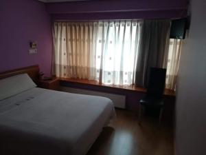 a bedroom with a bed and a window with curtains at Hostal Álvarez in Oviedo