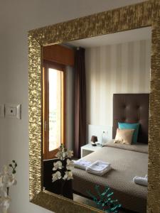 a mirror reflecting a bedroom with a bed and a window at Villa Arianna Panoramic Apartments in Malcesine