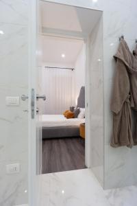 un baño con una puerta de cristal que conduce a un dormitorio en Suite Rodinò 24, en Nápoles