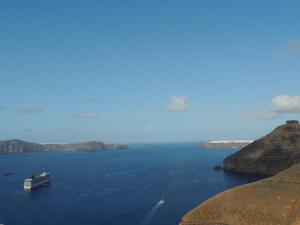 a large ship in the middle of a large body of water at Trieris Villa & Suites in Fira