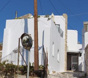 a mirror on the side of a white building at Guesthouse Casa De La Roca , Kostos , Paros in Kóstos