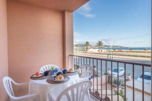 d'une table et de chaises sur un balcon avec vue sur la plage. dans l'établissement Empurialola -Apartamento en primera linea de mar -163, à Empuriabrava