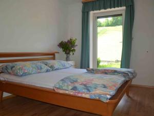 sypialnia z łóżkiem i oknem z wazą w obiekcie Ferienhaus Mitterbauer w mieście Oberhofen am Irrsee