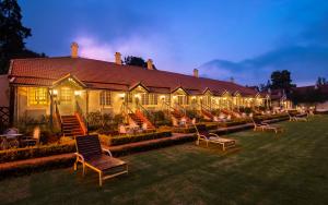 a large house with chairs and lights in the yard at Savoy - IHCL SeleQtions in Ooty