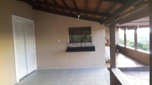 a living room with a tv on a wall at Sítio Santa Terezinha Canastra in São João Batista do Glória