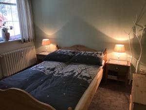 um quarto com uma cama e duas mesas de cabeceira com candeeiros em Villa Waidhof em Schierke