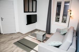 a living room with a couch and a tv at Oyonnappart in Oyonnax