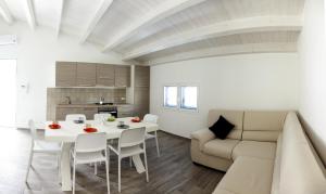 a living room with a white table and a couch at L'Ancora Holidays in Punta Secca
