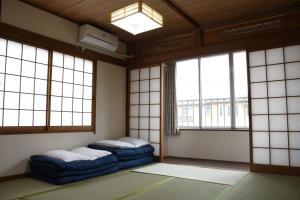 a room with two beds in a room with windows at Onsenyado Hamayu Nagi in Beppu