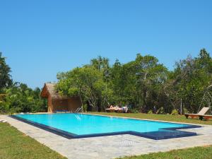 een zwembad in de tuin van een resort bij Happy Man Village in Bentota