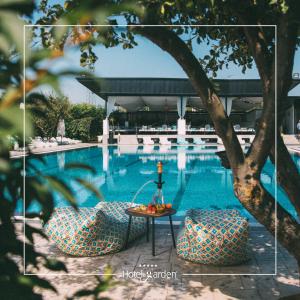 a picture of a pool with a table and chairs at Hotel Garden in Pristina