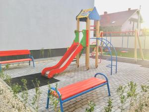 un parque infantil con un tobogán y un banco en квартира подобово en Úzhgorod