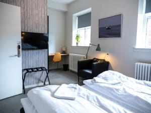 una camera con letto, scrivania e sedia di Hotel Residens Møen a Stege