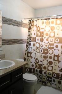uma casa de banho com um WC e uma cortina de chuveiro em Apartamento Amueblado Amplio Tranquilo Privado Como tu lo Mereces em Santiago de los Caballeros