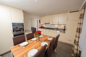 a dining room with a table and chairs and a kitchen at Haus City in Saas-Grund