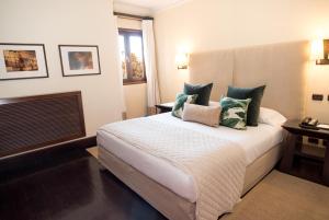 a bedroom with a large bed with pillows on it at Hotel Casa Higueras in Valparaíso +65 photos