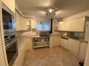 a large white kitchen with white cabinets and appliances at Ferienwohnung „Die 3 am Rhein“ in Rüdesheim am Rhein