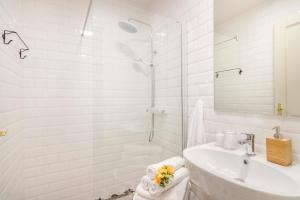 een witte badkamer met een wastafel en een douche bij Royal Apartments Prague by Michal&Friends in Praag