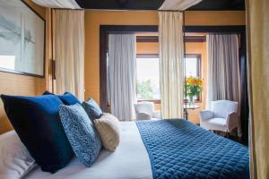 a bedroom with a large bed with blue pillows at Hotel Casa Higueras in Valparaíso