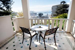 a table and chairs on a balcony with a view at Hotel Casa Higueras in Valparaíso