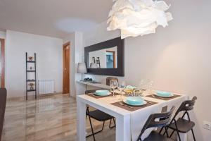 un comedor con una mesa con sillas y una lámpara de araña en Habitat Apartments Duna en Mataró