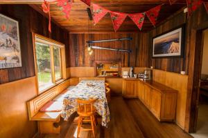Un comedor con una mesa y una cocina. en Lucky's Hostel, en Pucón