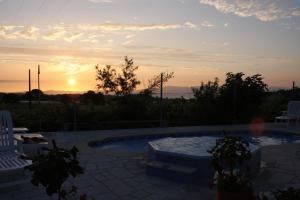 uma piscina com um pôr-do-sol ao fundo em O Lar da Avoa em Cambados