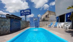 a swimming pool with a water fountain on a building at JR Hotel in João Pessoa